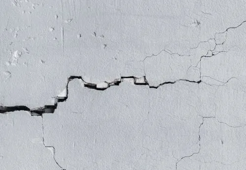 Close-up of a structural crack running through a concrete wall surface
