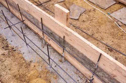Rebar tied inside wooden footing forms before a concrete pour in Charlotte, NC