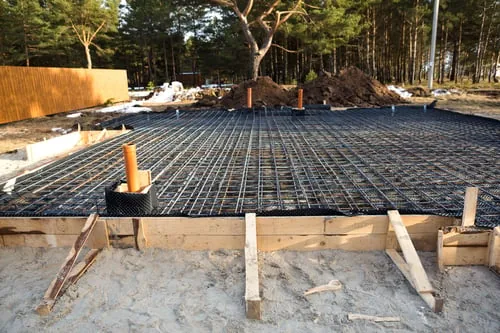 Rebar grid tied and set on chairs over a prepared slab base before a concrete pour